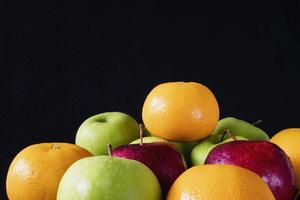 maçã verde vermelha fresca e laranja sobre fundo preto cinza - conceito de fundo de frutas frescas foto