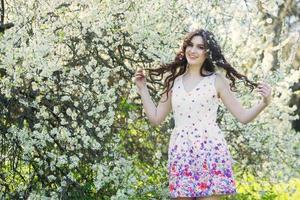 linda garota europeia branca com pele limpa no parque com árvores floridas foto