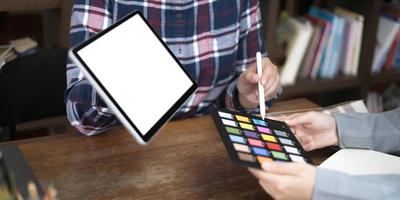 dois artistas trabalhando em tablet, tom de papel colorido no espaço de trabalho no escritório foto