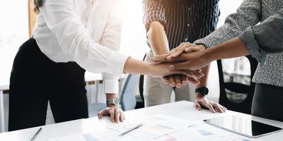 feche jovens empresários juntando as mãos. pilha de mãos. conceito de unidade e trabalho em equipe. foto