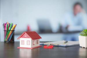 modelo de casa na mesa de madeira no escritório foto