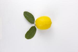 um limão amarelo fresco com folhas isoladas no conceito de fundo branco foto