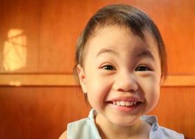 encantadora menina tailandesa asiática de 3 anos sorrindo em casa. foto