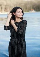 retrato de mulher com um cabelo se movendo ao vento. retrato de close-up de jovem morena russa linda no parque verde de verão. mulher branca europeia de vestido. foto