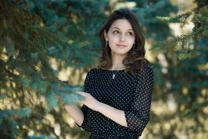 retrato de mulher com um cabelo se movendo ao vento. retrato de close-up de jovem morena russa linda no parque verde de verão. mulher branca europeia de vestido. foto