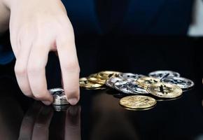 mulher segurando alguns pedaços de token bitcoin dourado foto