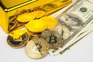 bitcoins dourados de novo dinheiro digital, dólares americanos e barras de ouro em fundo branco foto