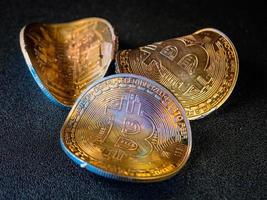 moedas de ouro torcidas com símbolo bitcoin. conceito de uma crise do mercado de criptomoedas. foto