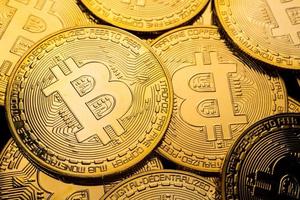 close-up de moedas de ouro com fundo de símbolo bitcoin. foto