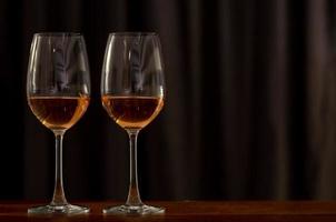 dois copos de vinho rosé na mesa de madeira para comemorar um casal. foto