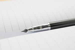 caneta-tinteiro em um notebook foto