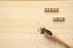 sementes de chia em uma placa de madeira com uma colher e uma inscrição, foto