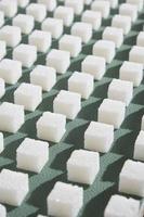 açúcar refinado em background.cubes verde de açúcar doce e branco em forma geométrica. sombras duras. foto