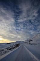 estrada gelada nas montanhas ao pôr do sol