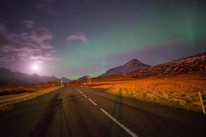 aurora boreal ou a aurora boreal e o anel viário vazio na cidade de stoovarfjorour, no leste da islândia. foto