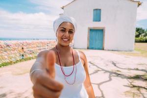 mulher brasileira feliz vestida com traje tradicional baiano, com o polegar para cima no centro histórico de porto seguro foto