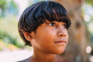 jovem índio da tribo pataxo do sul da bahia. criança indiana olhando para a direita. foco no rosto foto
