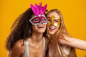 mulheres bonitas vestidas para a noite de carnaval. mulheres sorridentes prontas para curtir o carnaval com uma máscara colorida. foto