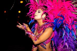 brasileiro vestindo fantasia de samba. linda mulher brasileira vestindo traje colorido e sorrindo durante o desfile de rua de carnaval no brasil. foto