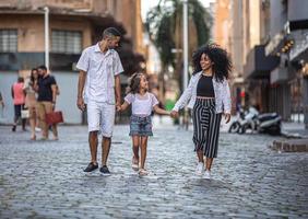 família tradicional brasileira. pai e mãe caminhando com sua filha. foto