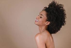 lado uma jovem afro latina sorridente. alegria, positivo e amor. lindo cabelo estilo africano. fundo de estúdio pastel. foto