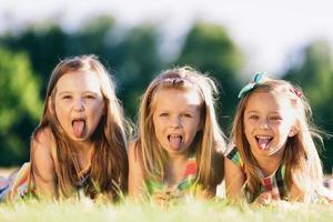 três meninas mostrando a língua foto