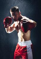 homem de boxe pronto para lutar na chuva. foto