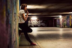 polônia, 2022 - garota estilosa de pé no túnel de grafite grunge, favela foto