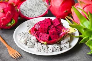 fruta do dragão roxo branco e vermelho fresco tropical no conceito de fruta saudável da Tailândia asiática, fatia de fruta do dragão na chapa branca com fundo de pitaia foto