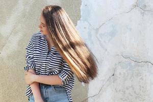 uma garota com longos cabelos escuros esvoaçando ao vento, uma garota com uma camisa de marinheiro foto