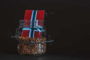 grão de trigo em uma jarra em torno de arame farpado, o conceito de sanções e a crise na noruega, problemas com grãos noruegueses, o bloqueio de grãos noruegueses. foto