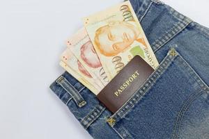fechar dólares de singapura com passaporte em um bolso jeans isolado no fundo branco, traçado de recorte foto