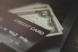 o cartão de crédito é colocado em cima da nota de dólar foto