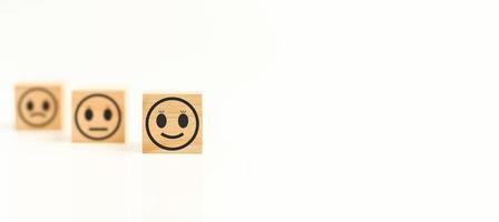 este feedback com sorriso rosto cubo de madeira feliz ícone de rosto sorridente para dar satisfação no serviço. classificação muito impressionado. preto, atendimento ao cliente e conceito de satisfação. copie o espaço, foco seletivo. foto