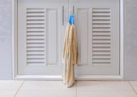 closeup da toalha de mão de tecido está pendurado perto da porta branca do armário. foto