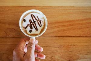 mulher segurando uma xícara de café na mesa foto