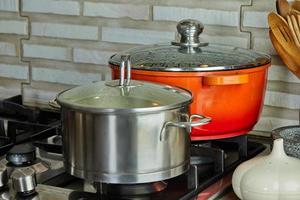 panelas com cozinhar alimentos na cozinha no fogão a gás foto