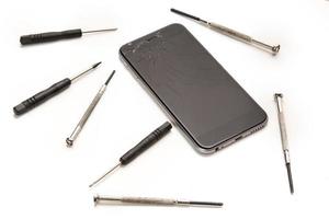 smartphone quebrado e pequenas chaves de fenda para reparo foto