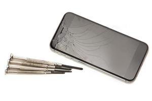 smartphone quebrado e pequenas chaves de fenda para reparo foto