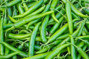 pilha de pimenta verde fresca para venda no mercado fresco foto