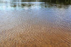 vista detalhada de perto em superfícies de água com ondulações e ondas e a luz do sol refletindo na superfície foto