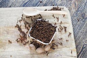 especiarias de cravo espalhadas em uma velha mesa de madeira foto