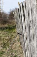 uma cerca de madeira velha que está quebrada foto