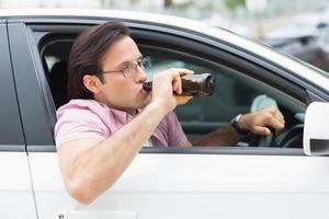 homem bebendo cerveja enquanto dirige foto