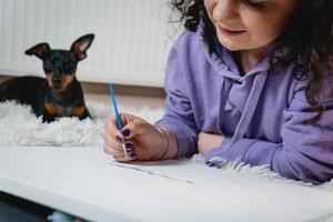 a mulher adulta pintando por números, cores pastel, desenhando em tela foto