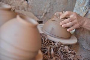 artesão marroquino joga uma panela de barro em uma roda de oleiro. foto