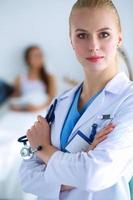 médico de mulher em pé com estetoscópio no hospital foto