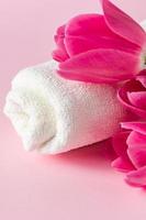 produtos de cuidados com a pele spa em um fundo rosa. cosméticos naturais e tulipas vermelhas. foto