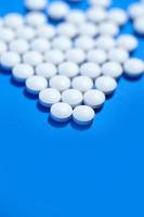 pílulas. comprimidos médicos brancos sobre fundo azul foto