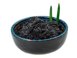 caviar preto em uma tigela no fundo branco foto